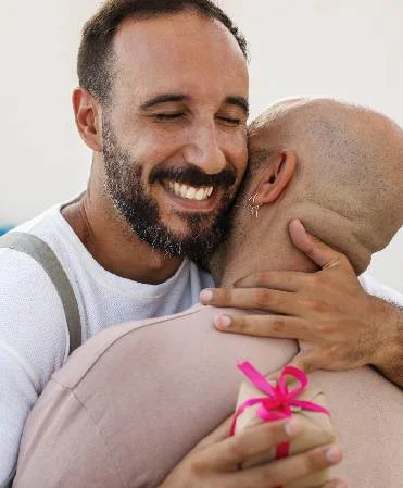 Two people embracing after transformative surgery