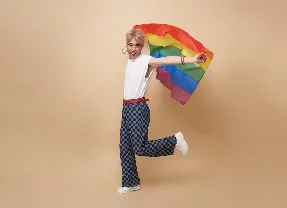 Individual celebrating joyfully with pride flag